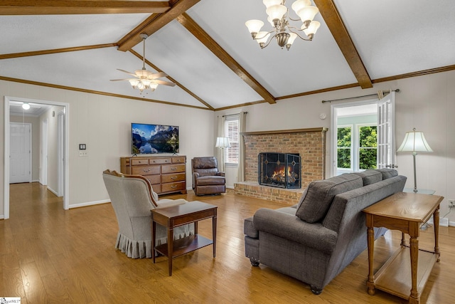 living room with light wood-type flooring, a chandelier, a fireplace, crown molding, and a ceiling fan