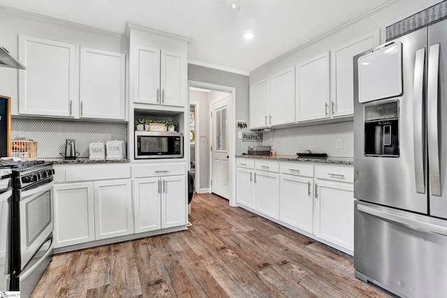 103 Mississippi Dr, Clinton, SC 29325 - kitchen featuring appliances with stainless steel finishes, ornamental molding, decorative backsplash, dark stone counters, and wood finished floors