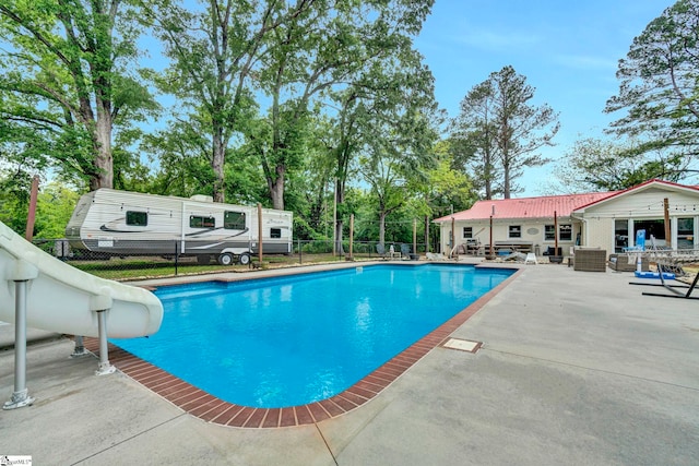 103 Mississippi Dr, Clinton, SC 29325 - outdoor pool featuring a water slide, a patio, fence, and view of wooded area