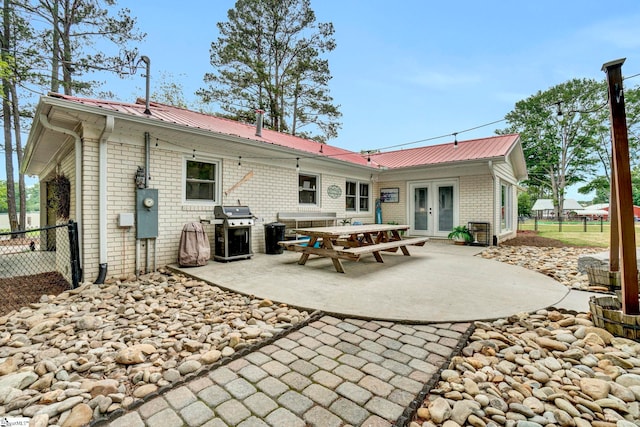 103 Mississippi Dr, Clinton, SC 29325 - back of house featuring french doors, brick siding, a patio, metal roof, and fence