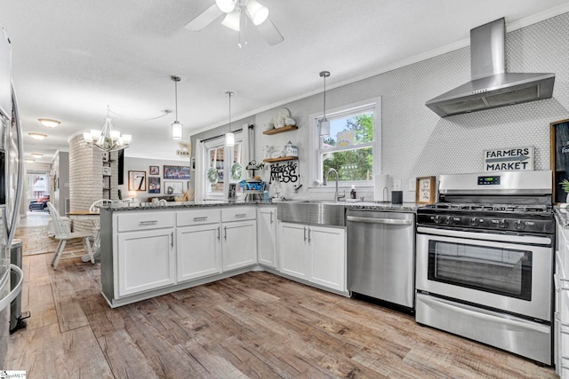 103 Mississippi Dr, Clinton, SC 29325 - kitchen featuring appliances with stainless steel finishes, wall chimney range hood, a sink, ornamental molding, and a peninsula