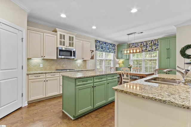 101 Belgian Blue Way, Fountain Inn, SC 29644 - kitchen featuring a sink, stainless steel appliances, green cabinetry, ornamental molding, and a kitchen island
