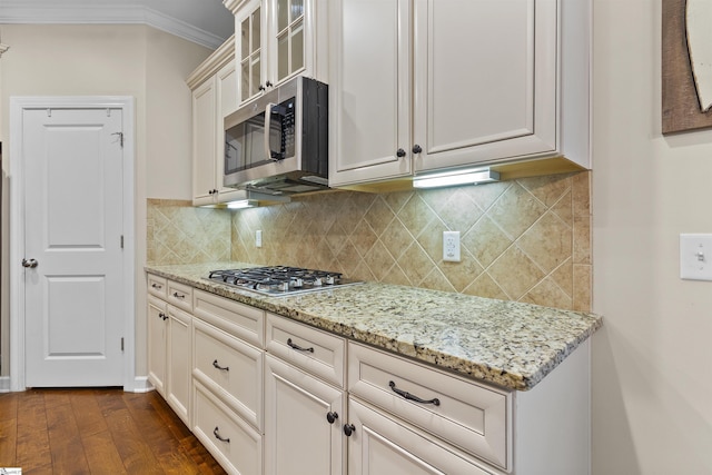 101 Belgian Blue Way, Fountain Inn, SC 29644 - kitchen featuring appliances with stainless steel finishes, crown molding, dark wood-style flooring, light stone countertops, and glass insert cabinets