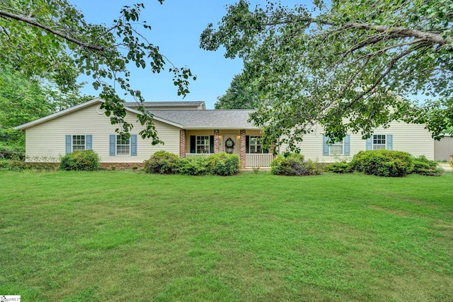 single story home featuring a front yard, covered porch, roof with shingles, and brick siding