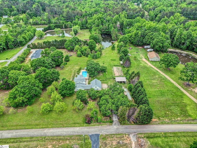 aerial view of property's location featuring a heavily wooded area and a large body of water