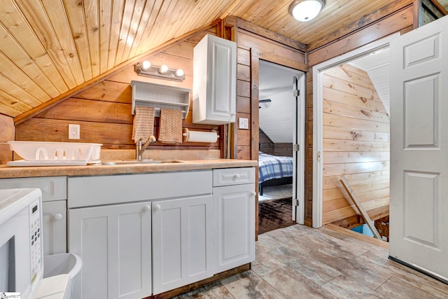 ensuite bathroom with wood walls, lofted ceiling, wooden ceiling, and vanity
