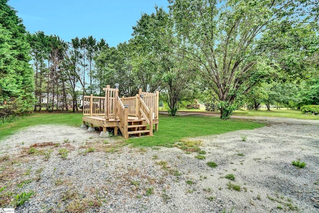 view of green lawn featuring a wooden deck