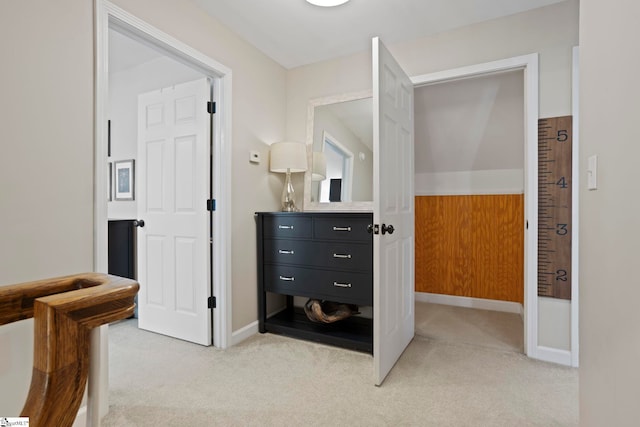 hall featuring light carpet and baseboards