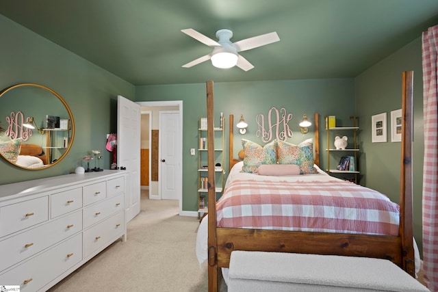 bedroom featuring light colored carpet, baseboards, and ceiling fan