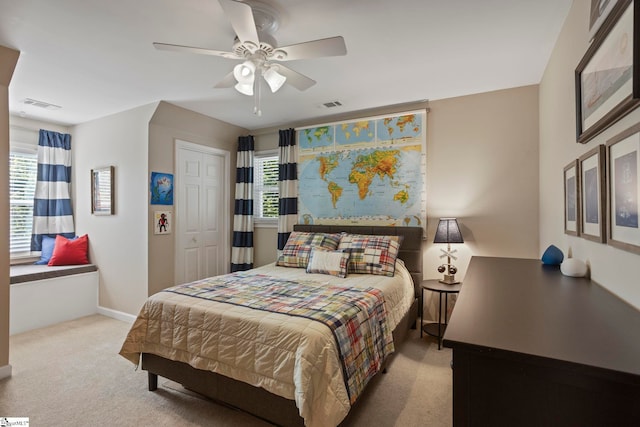 carpeted bedroom with multiple windows, a ceiling fan, and baseboards