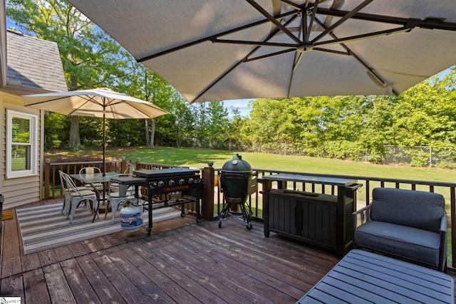 wooden deck featuring outdoor dining space and view of wooded area