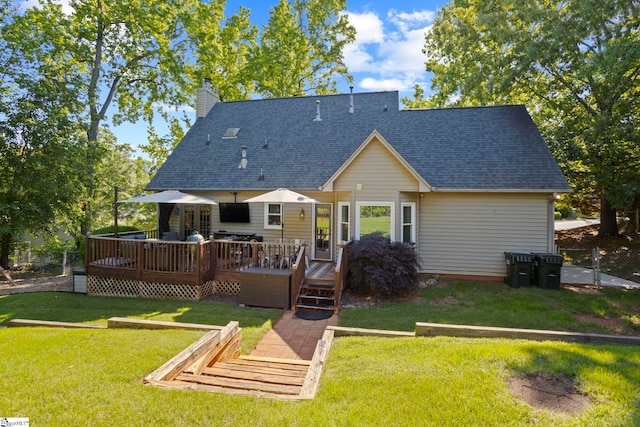 rear view of house with roof with shingles, a chimney, and a wooden deck