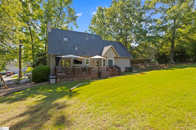 rear view of house featuring a wooden deck, a lawn, a chimney, and a shingled roof