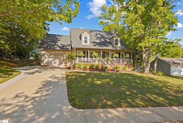 new england style home featuring covered porch, driveway, a garage, a front yard, and a chimney