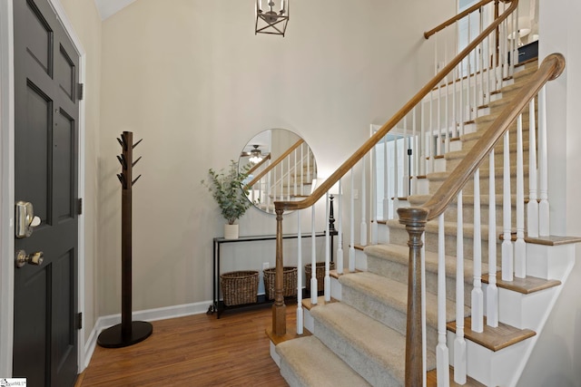 entrance foyer with stairway, wood finished floors, and baseboards