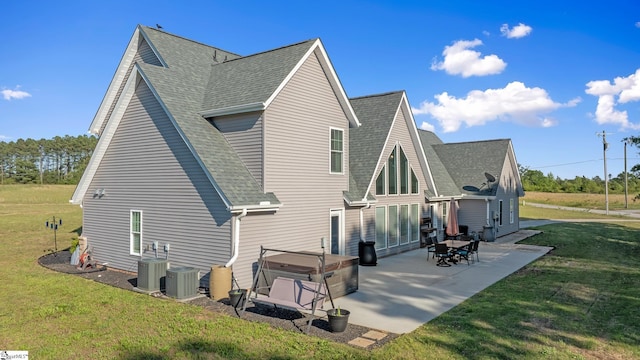 221 Wilsontown Rd, Laurens, SC 29360 - rear view of house featuring a hot tub, a shingled roof, a patio area, a lawn, and central air condition unit
