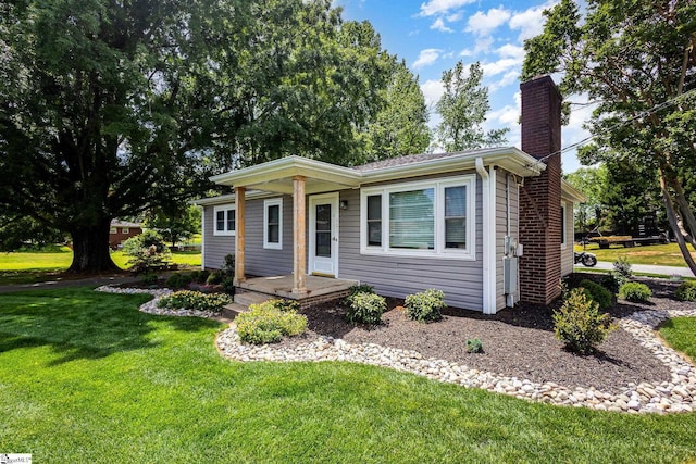 view of front of property with a chimney, a front lawn, and a porch
