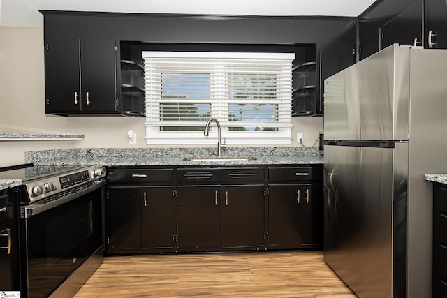 kitchen with stainless steel appliances, a sink, and dark cabinets