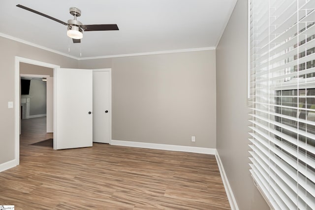 unfurnished bedroom with light wood-type flooring, baseboards, crown molding, and ceiling fan