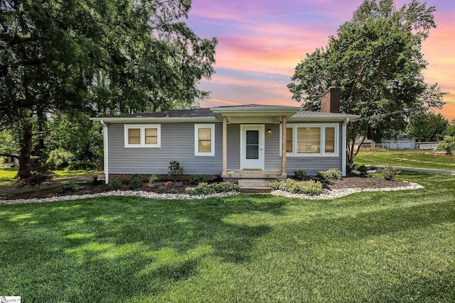 single story home with a chimney and a front lawn