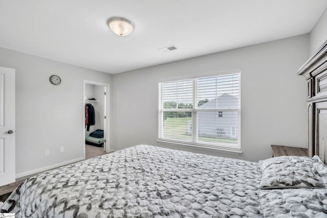 bedroom featuring baseboards, a spacious closet, and a closet