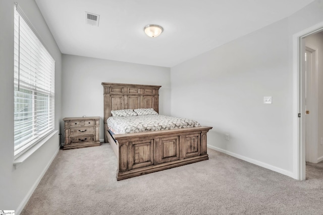 bedroom featuring light colored carpet and baseboards