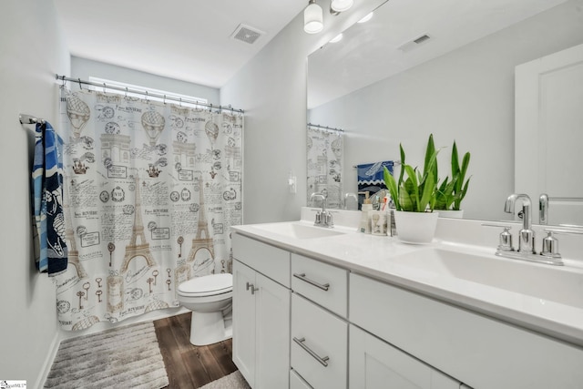 full bathroom featuring wood finished floors, toilet, double vanity, and a shower with curtain