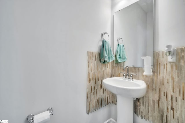 bathroom with tile walls and a sink