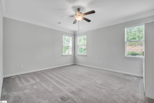 carpeted spare room featuring crown molding, ceiling fan, and baseboards
