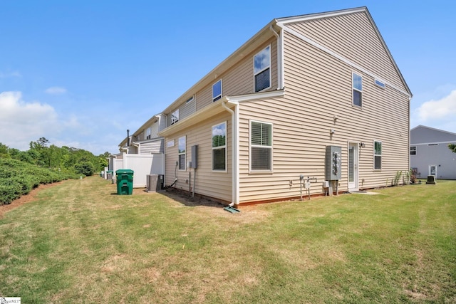 back of house featuring a yard and central air condition unit