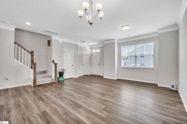 unfurnished living room with wood finished floors, stairway, a chandelier, ornamental molding, and baseboards