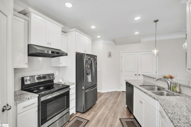 kitchen featuring stainless steel appliances, under cabinet range hood, a sink, crown molding, and white cabinets