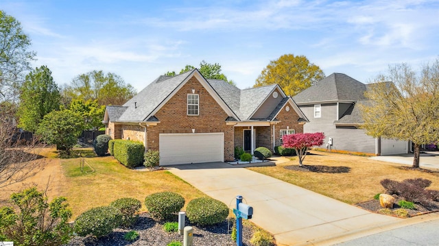 traditional-style house with brick siding, an attached garage, driveway, and a front yard