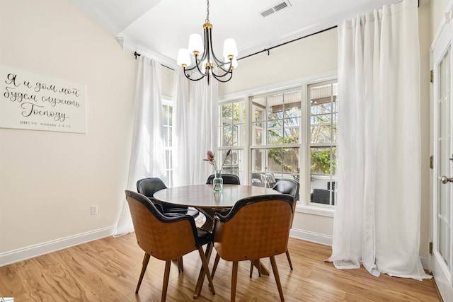 dining room with a chandelier, baseboards, and light wood-type flooring