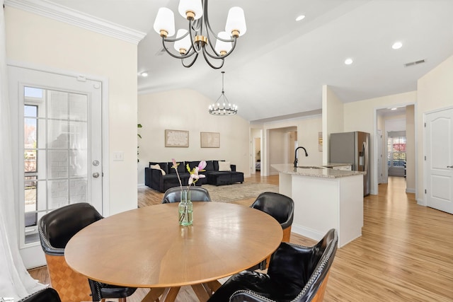dining space with a chandelier, vaulted ceiling, light wood-style floors, ornamental molding, and recessed lighting