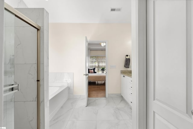 bathroom featuring marble finish flooring, connected bathroom, a garden tub, a marble finish shower, and vanity