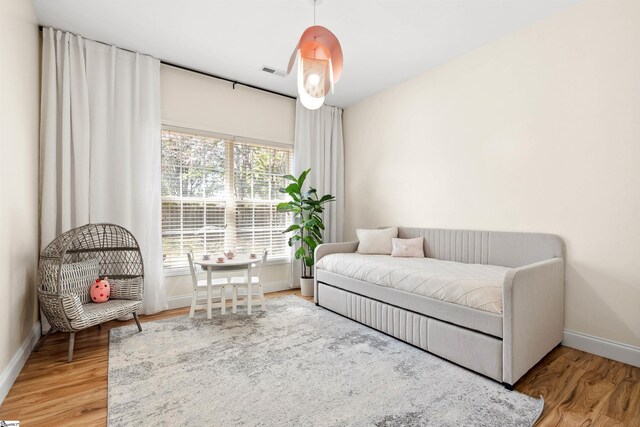 living area featuring baseboards and light wood finished floors