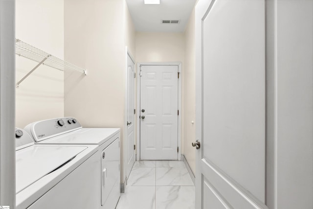 washroom featuring washing machine and clothes dryer and light marble finish floors