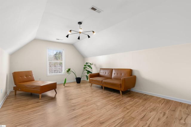living area featuring light wood-type flooring, lofted ceiling, baseboards, and a chandelier