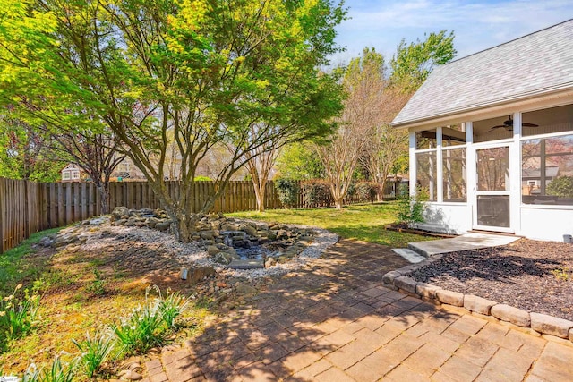view of patio / terrace with a sunroom, a fenced backyard, and a ceiling fan