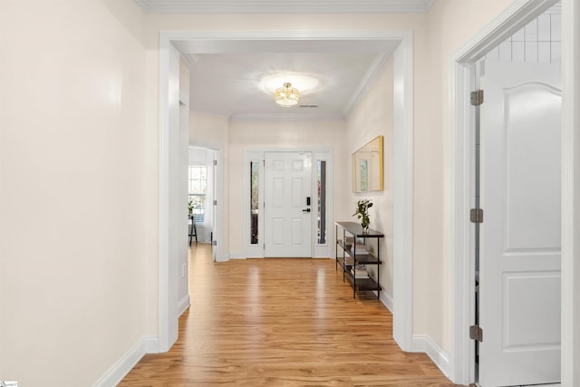 entrance foyer with light wood-style flooring, ornamental molding, and baseboards