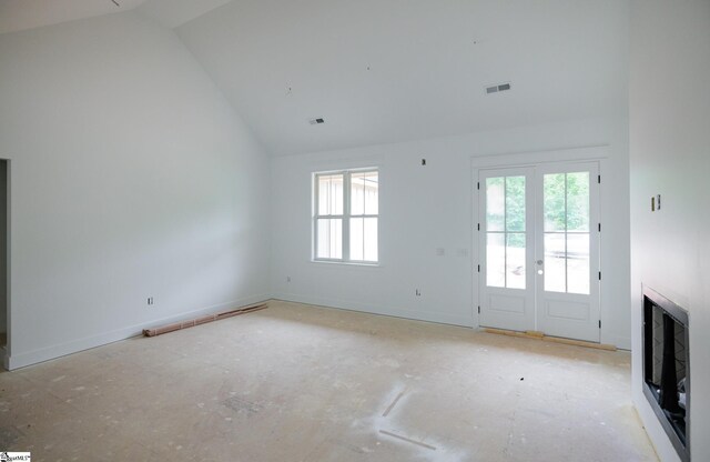 unfurnished living room featuring high vaulted ceiling