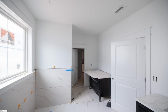 bathroom featuring marble finish flooring
