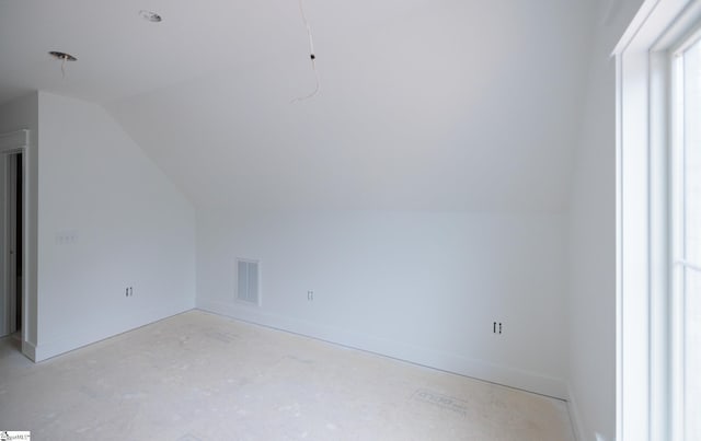 bonus room with vaulted ceiling and baseboards