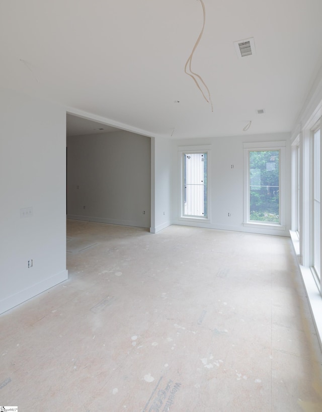 unfurnished room with baseboards