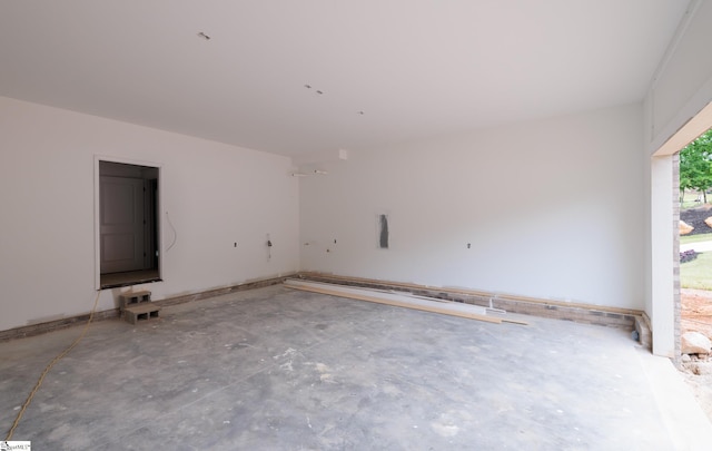 unfurnished room with unfinished concrete flooring