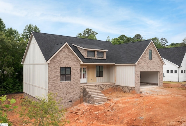 view of front of house with brick siding, crawl space, covered porch, roof with shingles, and board and batten siding