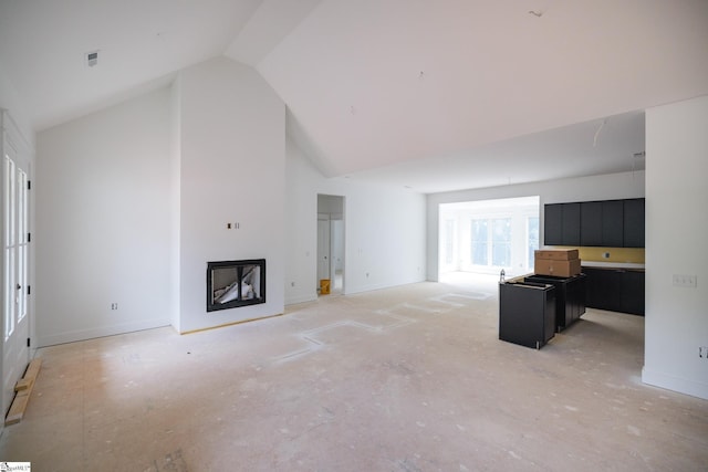 unfurnished living room with high vaulted ceiling, a fireplace, and baseboards