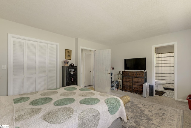 carpeted bedroom with a closet and ensuite bathroom