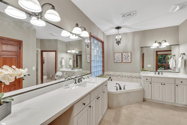 bathroom with a bath, tile patterned flooring, two vanities, and toilet